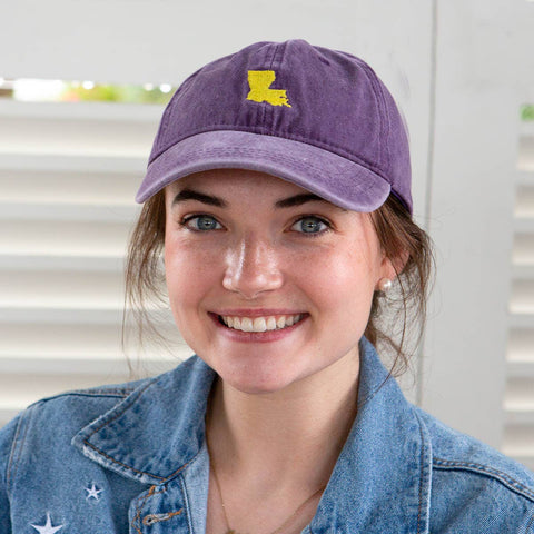 Purple cap with gold Louisiana embroidered on the front.  Metal buckle adjustable back. 